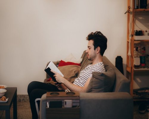 person reading a book in a comfortable room
