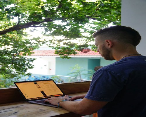 person working on a laptop beside a bright window in Mexico